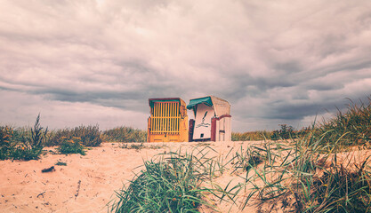 Strandkörbe im stürmischem Wetter am Strand in Cuxhaven an der deutschen Nordseeküste. Körbe in...