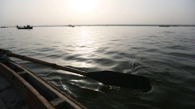 Close-up of wooden boat paddle rowing on surface of the water on river in Varanasi
