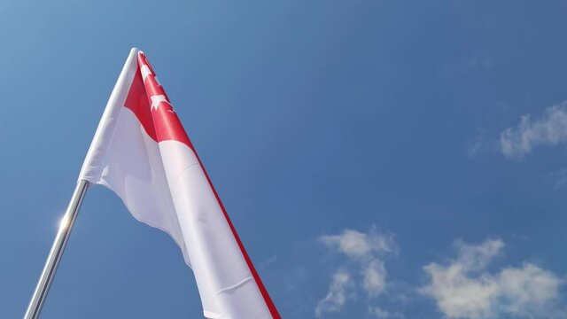 Singapore. National country flag on blue sky background. Flying fabric symbol. Tourism or travel summer day. international patriotic emblem. Nobody. Horizontal video