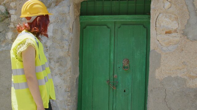 Soccorritore donna va verso la casa disastrata dal sisma