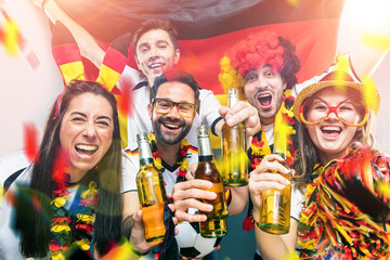 Gruppe glücklicher Fußballfans aus Deutschland feiern gemeinsam einen Meisterschaft Sieg.
