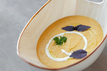 Vegetable cream soup in bowl on gray table