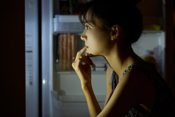 Fototapeta na wymiar 深夜に食事をする若い女性