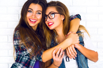 Close up lifestyle portrait of two pretty teen girlfriends