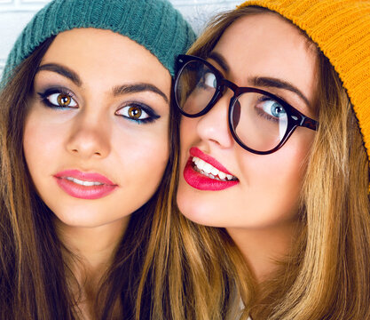 Close up fashion portrait of two young pretty hipster girls