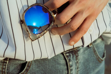 Hands of a man holding sunglasses