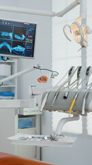Interior of empty stomatology orthodontist office with nobody in it prepared for tooth surgery. Zoom in shot of teeth radiography on monitor. Orthodontic clinic with professional dentist equipment