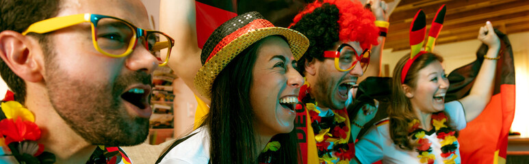 Gruppe glücklicher Fußballfans aus Deutschland feiern gemeinsam einen Meisterschaft Sieg.
