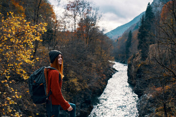 woman hiker with backpack in the mountains autumn forest