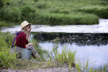 Girl by the river with a fishing rod