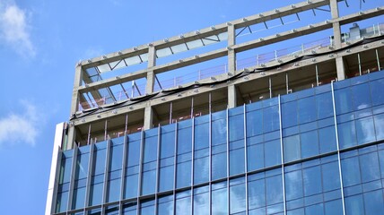Obraz premium High-rise building under construction. Modern office building. Sunrise.