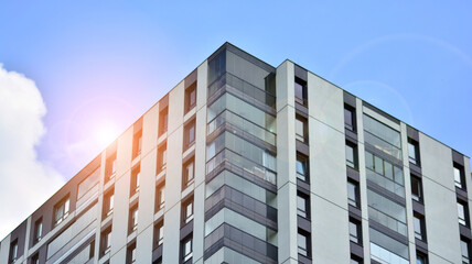 Modern apartment buildings on a sunny day with a blue sky. Facade of a modern apartment building. Glass surface with sunlight.