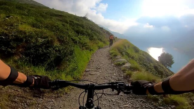 POV Mountain Biker Following a Rider on the Exposed Barbellino Trail Above Lake Barbellino, Orobie Alps