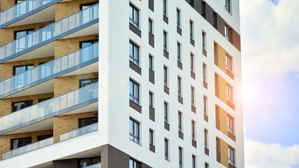 Modern apartment buildings on a sunny day with a blue sky. Facade of a modern apartment building. Glass surface with sunlight.