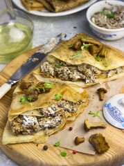 pancakes with filling lie on a wooden board on a blue background. healthy food, home food, baking, comfort, cooking concept