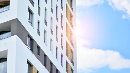 Modern apartment buildings on a sunny day with a blue sky. Facade of a modern apartment building. Glass surface with sunlight.