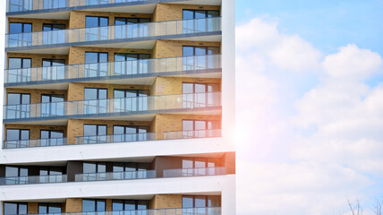 Fototapeta premium Modern apartment buildings on a sunny day with a blue sky. Facade of a modern apartment building. Glass surface with sunlight.