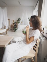 young woman cuts an apple, drinks apple juice, green smoothie, vitamins