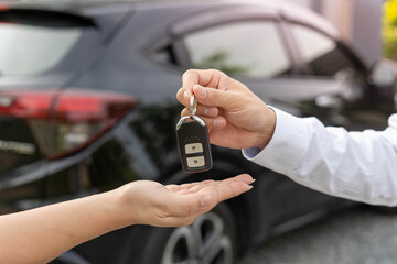 selling car, car sale, deal concept The dealer gives the car keys to the new owner or renter with...