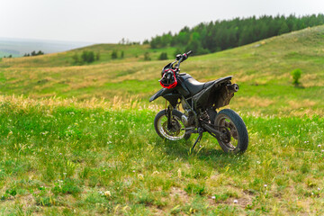 Obraz na płótnie Canvas The motorcycle stands on a hill overlooking a beautiful landscape with green meadows. Togliatti, Russia - 20 May 2021: