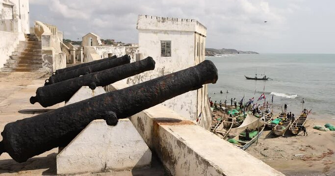 Cape Coast Ghana castle canon over fishing village. Cape Coast Castle is one of  forty slave castles, or forts, built on the Gold Coast of West Africa, now Ghana by European traders.