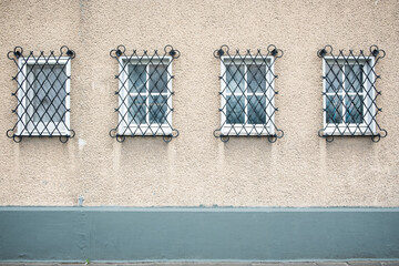 Vier vergitterte Fenster eines Hauses