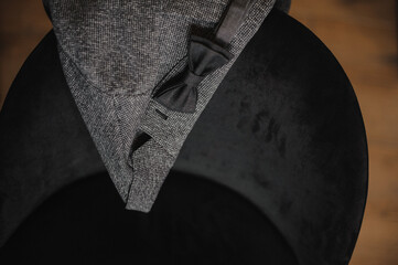men's gray blazer with black bow tie on the chair