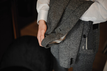 a man holding a gray jacket in his hand