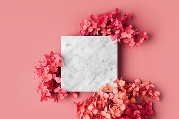 Square marble plate on pink background with flowers. Stylish background for presentation.