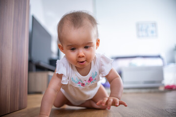 Fototapeta premium Portrait of child on all fours in bright indoors. Lifestyle background