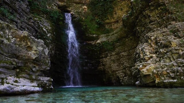 Tranquil place on canyon with waterfall inside high cliffs and lush vegetation in Albania