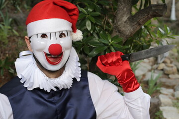 Macabre clown with Santa hat holding a large knife