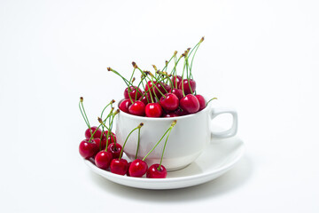 Red cherries in a mug on a white background. Sweet cherry with tails. Healthy food