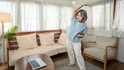 Senior elderly old woman follow virtual exercise online video at home