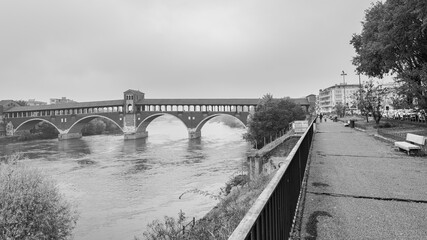 The famous bridge of Pavia, Italy, named "Ponte Coperto" (meaning: Covered Bridge). It crosses one important italian river, named Ticino. Black and white.