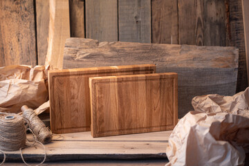 Composition of cutting boards. Oak planks. Free copy space. In the background wrapping paper, string and wooden boards. 