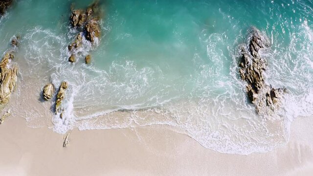 4K Aerial drone top down view bird eye view of sea blue waves break on rock and sand. Beautiful of sea water wave come to beach. Phuket Thailand tropical beach