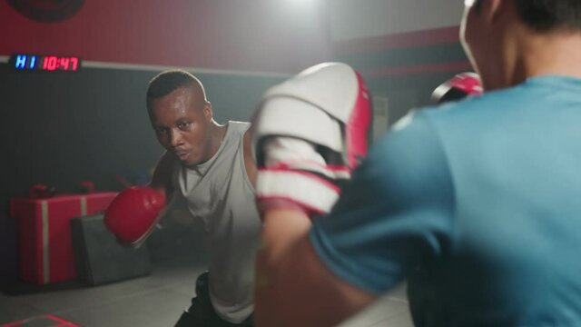 Fitness boxer trainer motivate sportsman exercise boxing, punch at gym
