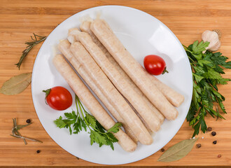 Top view of raw chicken sausages with spices on dish