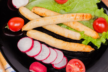 Baked chicken sausages with vegetables, top view close-up