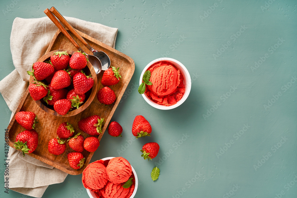 Aufkleber Strawberry sorbet with strawberries on blue background with copy space. Heap of strawberry with cups of ice cream.