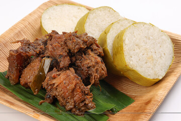 pulut lemang sticky rice steam cooked inside bamboo with beef rendang curry cooked sipce and coconut milk on palm leaf disposable square plate malay festival food
