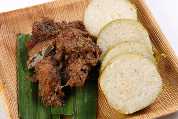 pulut lemang sticky rice steam cooked inside bamboo with beef rendang curry cooked sipce and coconut milk on palm leaf disposable square plate malay festival food