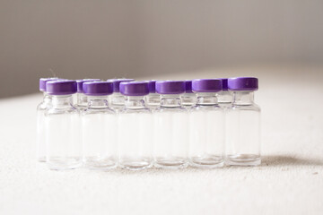 Empty glass jars of coronavirus vaccines