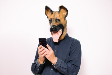person with a dog mask consulting the telephone