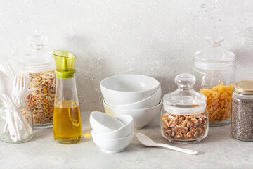 Obraz na płótnie Canvas kitchen utensils on modern simple counter, kitchenware jars with dry ingredients bowls