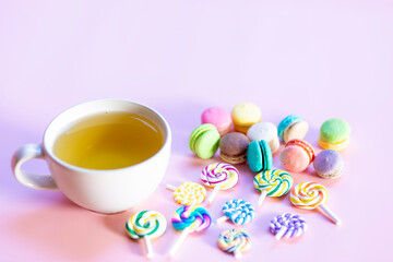 Sweets and tea on the pink table look delicious.