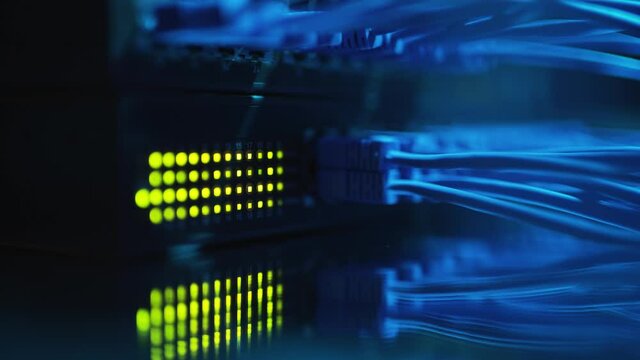 Close up fiber optic in server room. Network cables installed in the rack at data center. Ethernet cable on network switches background