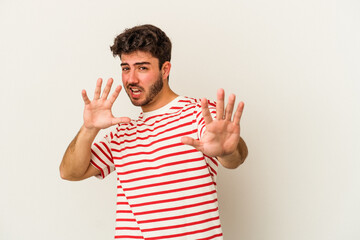Young caucasian man isolated on white background rejecting someone showing a gesture of disgust.