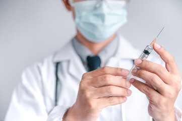 Doctor or scientist carries a syringe and a vaccine against COVID-19, vaccination and laboratory...